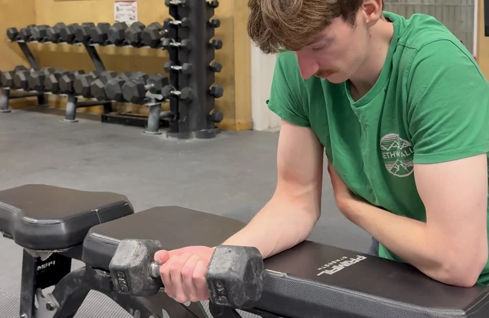 Matt demonstrating a wrist-flexion exercise at the climbing gym